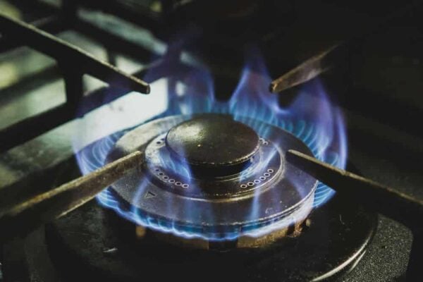 Gas stove burner with a visible blue flame during operation