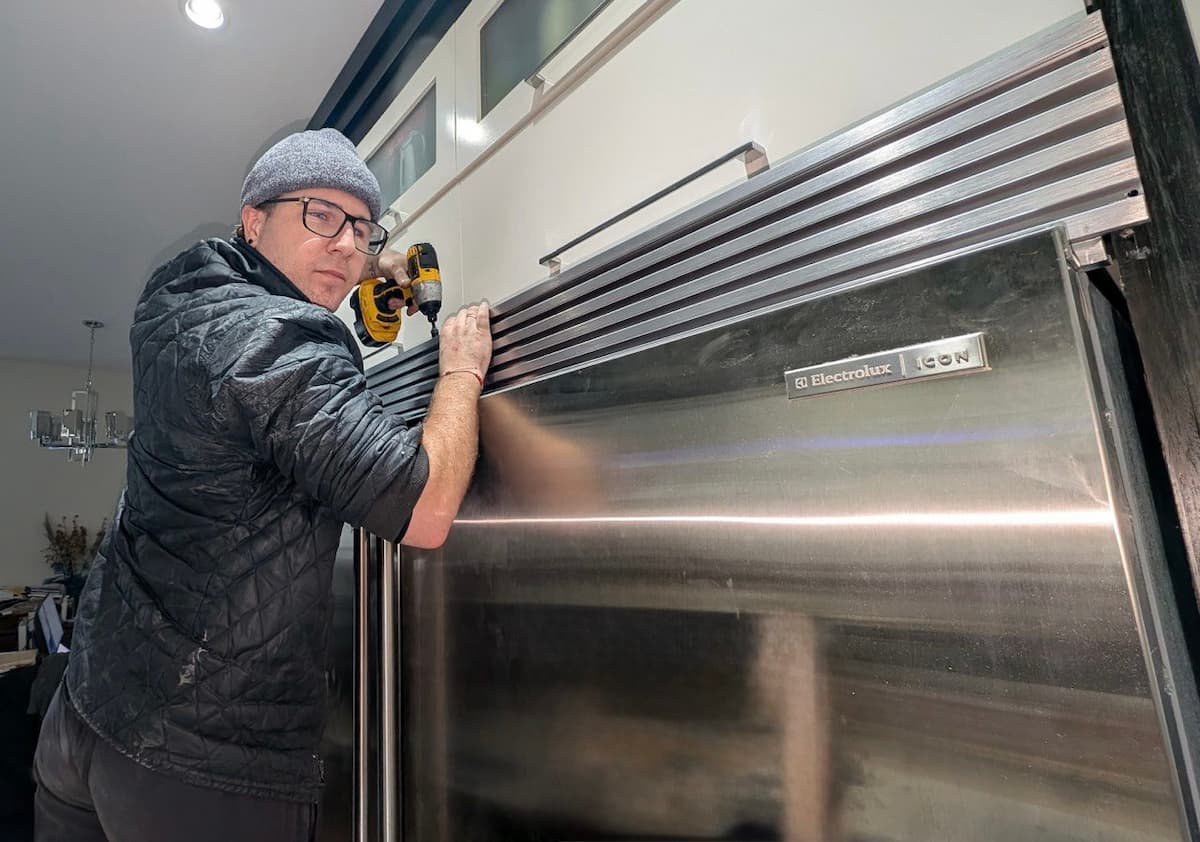 Certified appliance repair technician servicing an Electrolux refrigerator in a Maple Ridge home