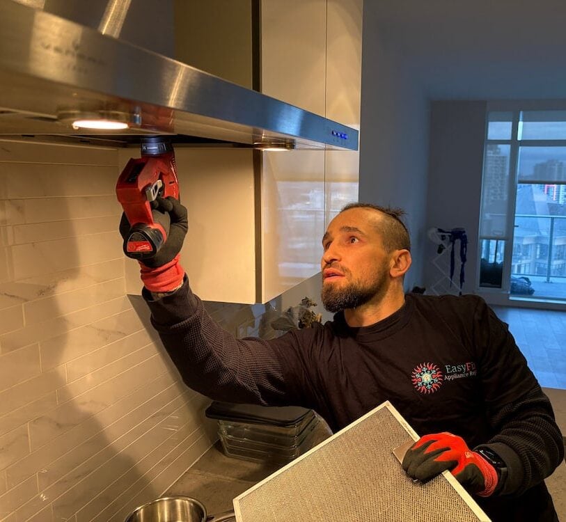 EasyFix Appliance Repair owner repairing a kitchen hood fan in a Vancouver condo