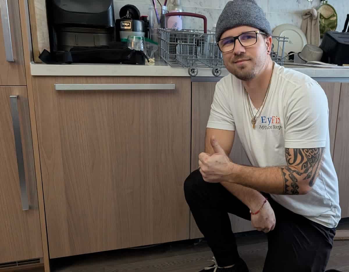 Appliance repair technician Vlad completing dishwasher repair in Burnaby BC kitchen
